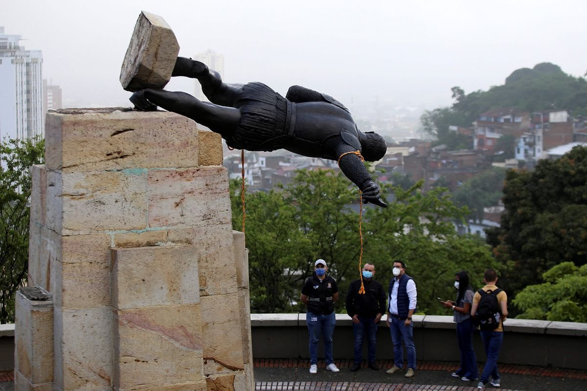 Estatua de Sebastián de Belalcázar siendo derribada en Cali, Colombia. Se ven personas observando.