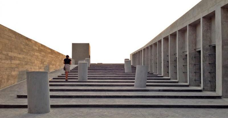 Persona subiendo las escaleras del Lugar de la Memoria, con arquitectura moderna de hormigón.