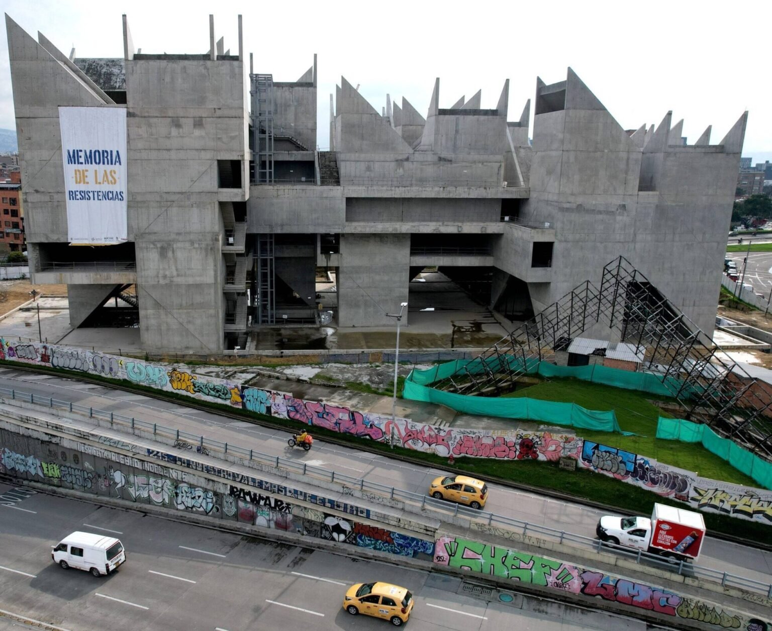 Vista exterior del Museo de la Memoria de Medellín durante su construcción, con una pancarta que dice 'Memoria de las Resistencias'.