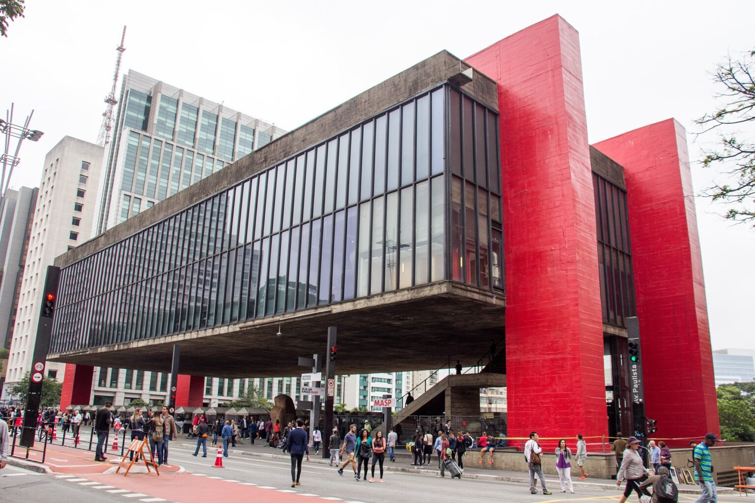 Vista exterior del Museo de Arte de São Paulo (MASP) mostrando su arquitectura distintiva y la gente caminando por la Avenida Paulista.