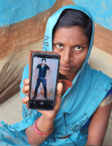 Mujer india sostiene un móvil mostrando la foto de un hombre, parte de la historia 'DETRÁS DE LA PASIÓN'.