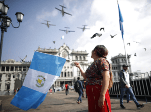 Una mujer sostiene la bandera de Guatemala frente al Congreso durante la incertidumbre en la investidura de Bernardo Arévalo.