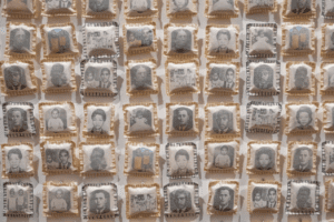 Detalle de la obra de Rosana Paulino con múltiples almohadas pequeñas cosidas con imágenes fotográficas en blanco y negro.